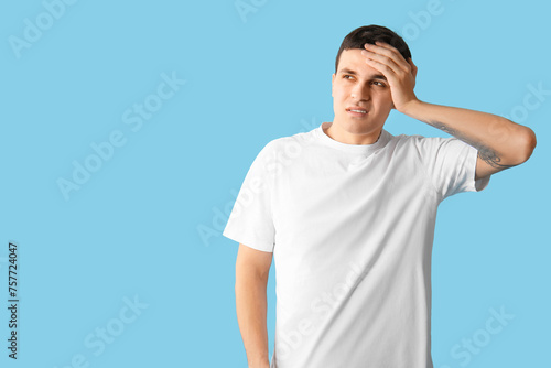 Tired young man on blue bac...