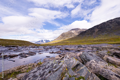A small, rocky mountain stream in Sarek National Park, Sweden. A beautiful summer landscape with water flow in Northern Europe wilderness.
