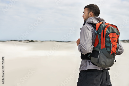 Hike, dunes and male person in nature for adventure, desert landscape and travel for holiday. Fitness, explorer and nomad man people in Sahara terrain, outdoor or workout in dry climate and scenery photo