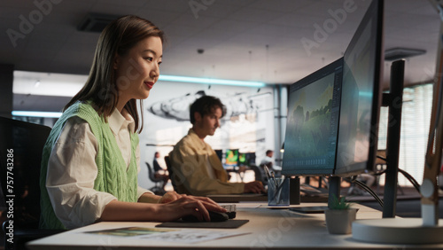 Asian Woman Using Desktop Computer And Designing In 3D Modelling Software Unique World And Characters For Survival Video Game In Diverse Office. Female Game Developer Creating Immersive Gameplay © Gorodenkoff