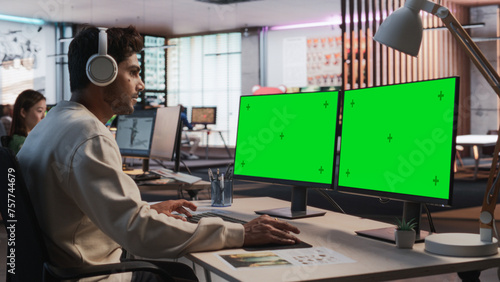 Fotografie Indian Male Game Designer Using Desktop Computer With Green Screen Chromakey on Display, Designing Immersive World In 3D modelling Software For RPG Video Game