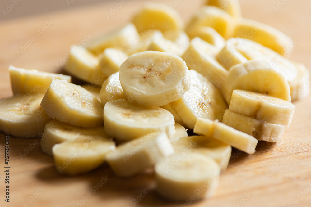 shot of banana slices arranged on a wooden cutting board shot of banana slices arranged on a wooden cutting board