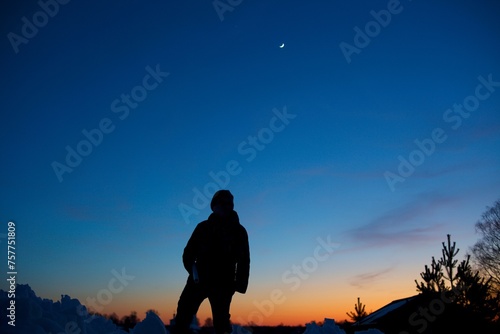 Silhouette of a man walking through the mountains against the backdrop of the night before dawn sky without clouds. Only man and nature. Clean mountain air.