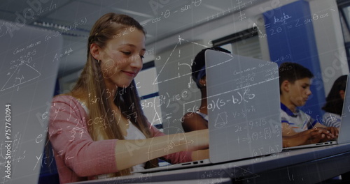 Image of mathematical equations over schoolchildren using laptop