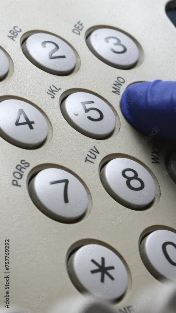 A Doctor's Hand Picks Up The Phone And Dials A Phone Number On The White Numpad Of A Landline In The Office. Vertical. A Doctor's Hand Picks Up The Phone And Dials A Phone Number On The White Numpad Of A Landline In The Office. Vertical.