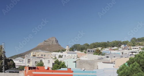 General view of cityscape with houses, mountain, trees and blue sky