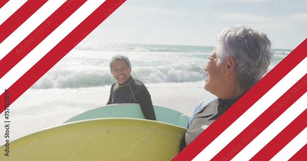 Image of flag of united states of america over senior biracial couple with surfboard on beach Image of flag of united states of america over senior biracial couple with surfboard on beach