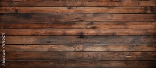 A closeup of a hardwood plank wall with a brown wood stain, showcasing the natural pattern of the building material. The blurred background highlights the beauty of the hardwood flooring