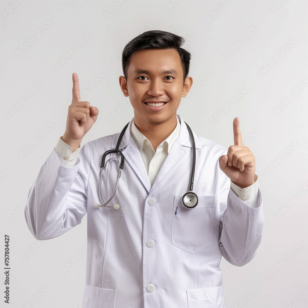 Handsome young south east asian man wearing doctor uniform and stethoscope showing and pointing up with finger number one while smiling confident and happy. Handsome young south east asian man wearing doctor uniform and stethoscope showing and pointing up with finger number one while smiling confident and happy.