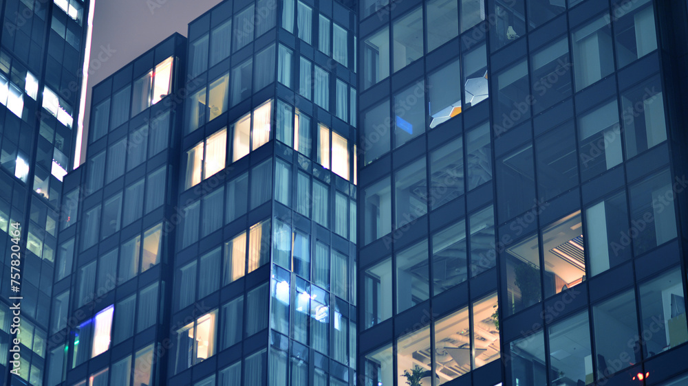 Office building at night, building facade with glass and lights. View with illuminated modern skyscraper. Office building at night, building facade with glass and lights. View with illuminated modern skyscraper.
