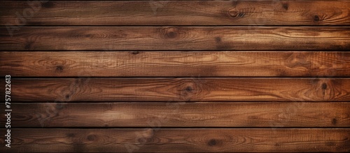 A close up of a brown hardwood plank flooring with a wood stain, creating a beautiful pattern of rectangles. The background is blurred to highlight the details of the wood