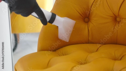 Close-up of sofa's wet cleaning process using specialized equipment, including a vacuum cleaner equipped with a humidifier for thorough and effective cleaning.