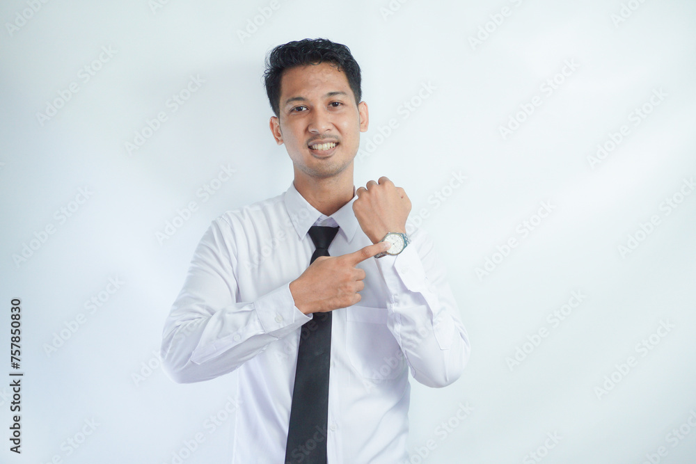 Adult Asian man smiling happy while pointing to his watch Adult Asian man smiling happy while pointing to his watch