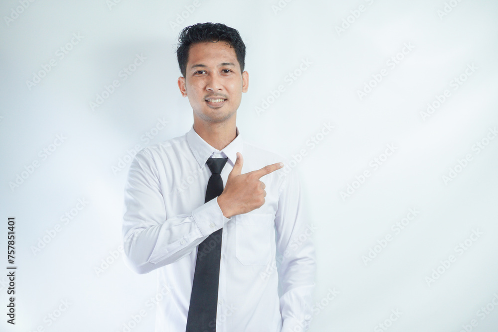 Adult Asian man pointing finger to the left with smiling face Adult Asian man pointing finger to the left with smiling face