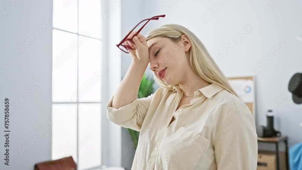 A fatigued young woman in an office setting holds her glasses, embodying workplace stress and exhaustion. A fatigued young woman in an office setting holds her glasses, embodying workplace stress and exhaustion.