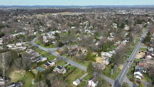 Noble American Suburb Neighborhood with cars on road during spring season. Aerial rising top down shot.