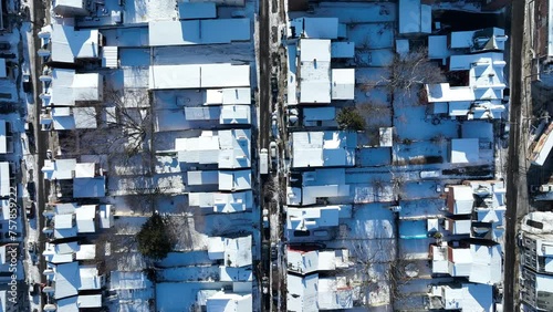 Densely populated American Neighborhood with snow covered roofs. Suburb district during sunlight in USA. Aerial top down flyover. photo