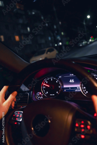 Driver's hands on the steering wheel of a car at night, night driving. © puhimec