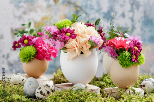 Florist at work: woman shows how to make simple Easter decoration with egg shell and various flowers.