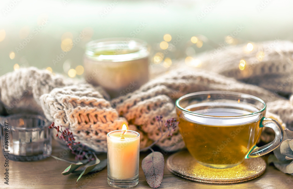 Glass cup of herbal tea, candles and knitted element. Glass cup of herbal tea, candles and knitted element.