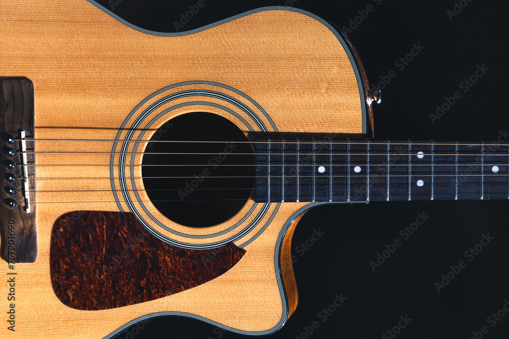 Acoustic guitar on a black background, flat lay.