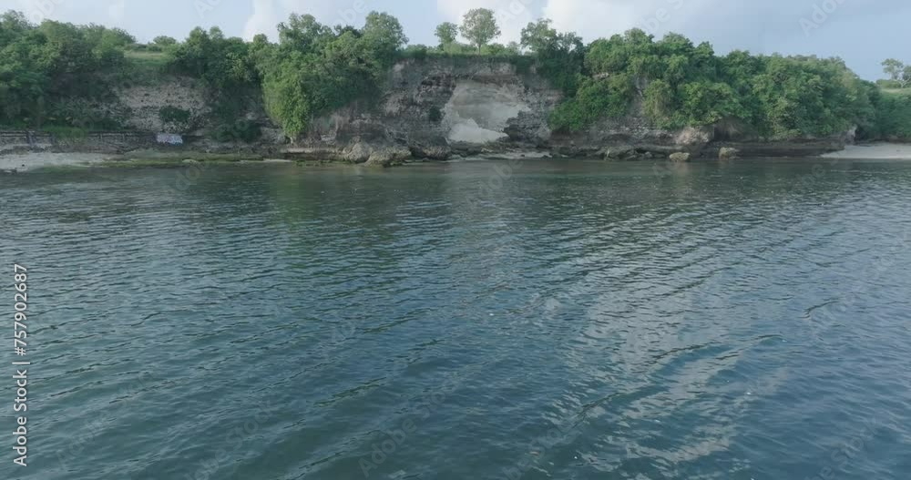 Low altitude dolly drone shot of polluted water filled with floating trash in the turqouise tropical water of Bali Indonesia Low altitude dolly drone shot of polluted water filled with floating trash in the turqouise tropical water of Bali Indonesia