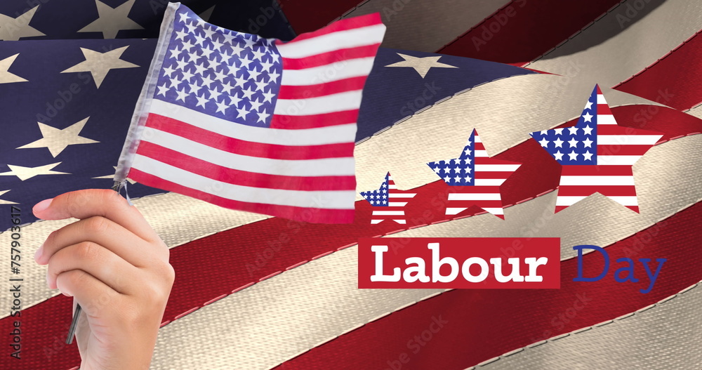 Obraz premium Image of labor day text with american flag stars and hand holding flag, over american flag