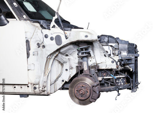 The front part of the car after an accident in a car repair service with a disassembled hood and metal grille and various parts in the garage box.