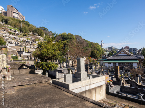 Buddhist cemetery at Nishizaka hill with roofs of Shorinzan Honrenji and Kannon statue of Fukusaiji temple at the distance - Nagasaki, Japan