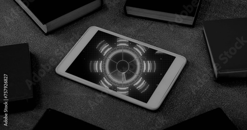 Black and white image of blue circular scanner processing data on screen of smartphone on desk