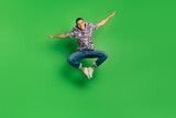 Full length photo of glad funky positive man open hands flight travel vacation isolated on green color background