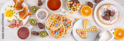 Easter breakfast or brunch. Cute creative decor portion of soft sweet belgian waffles with Easter chocolate eggs, sugar sprinkles and jam or syrup drizzles photo