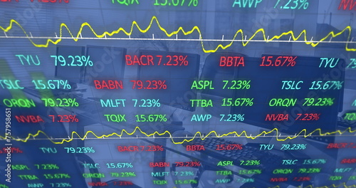 Image of graphs and trading board moving over desktops and keyboards on desk at office