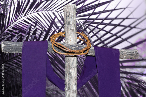 wooden cross, crown of thorns and purple fabric
