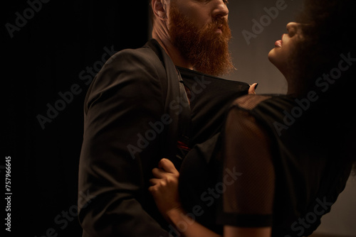 cropped african american woman in dress pulling blazer of bearded man during date, sexy couple