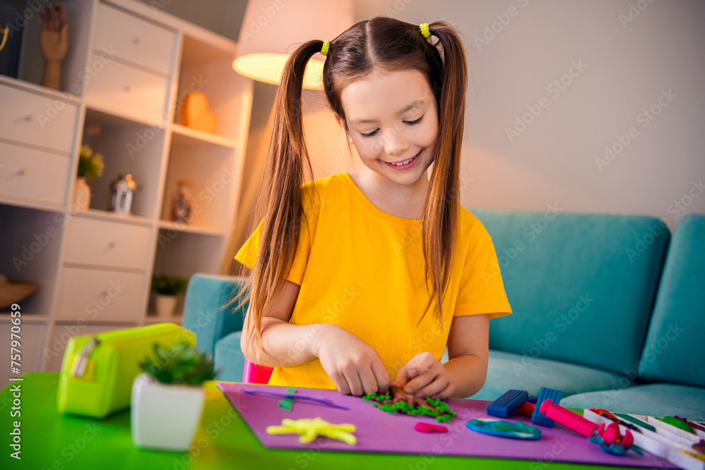 Photo of lovely cheerful happy child making plasticine handmade craft evening hobby time indoors house home room Photo of lovely cheerful happy child making plasticine handmade craft evening hobby time indoors house home room