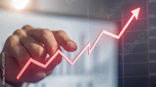 Person hand pointing at an increasing stock market or financial graph