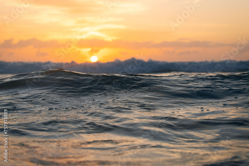 View of ocean water surface with warm sunrise light.