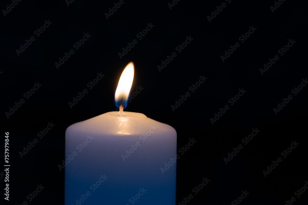 Simple white burning candle at night black background. Simple white burning candle at night black background.