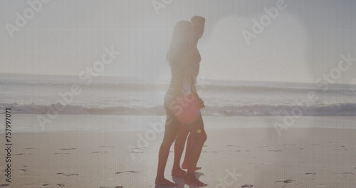 Image of light spots over caucasian couple walking at beach