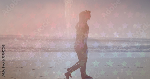 Multiple star icons against caucasian couple walking together on the beach