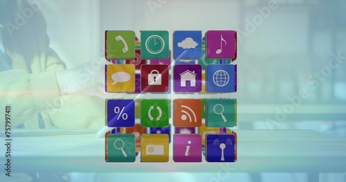 Image of cube with icons over person using tablet