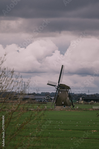 Landscape with ancient windmills in the Netherlands in gloomy spring weather. Stormy day over Dutch village of Streefkerk, Alblasserwaard, South Holland photo