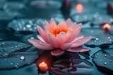 A pink lotus flower bloom on calm water, surrounded by candles, evokes a sense of peace and spirituality