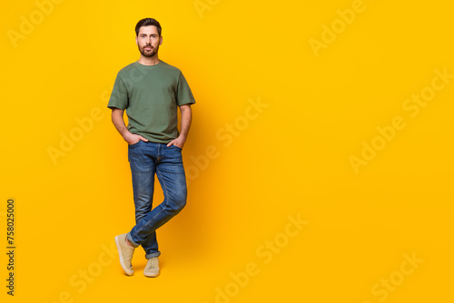 Full length photo of attractive positive guy dressed green t-shirt walking empty space isolated yellow color background