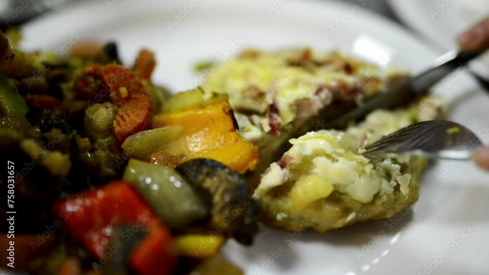 Tasty chicken cutlet with vegetable side dish. Woman cuts cutlet with knife. Tasty chicken cutlet with vegetable side dish. Woman cuts cutlet with knife.