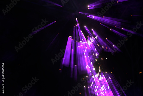 On a dark background, purple lazar rays from stage spotlights. photo