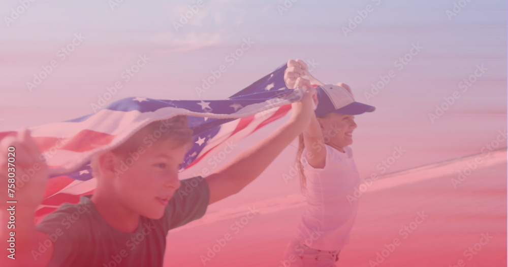 Naklejka premium Caucasian brother and sister with american flags running at the beach