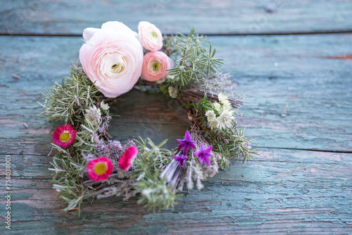 Spring floristry with herbs and flowers on weathered wood. Natural spring decoration. Top view.