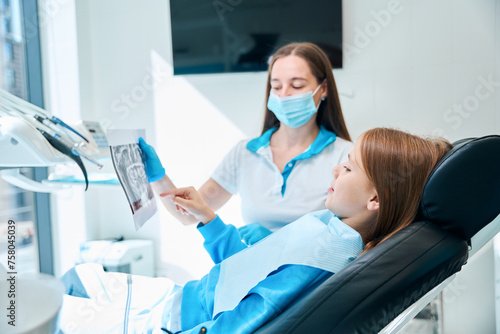 Clinic employee shows the girl a picture of her teeth